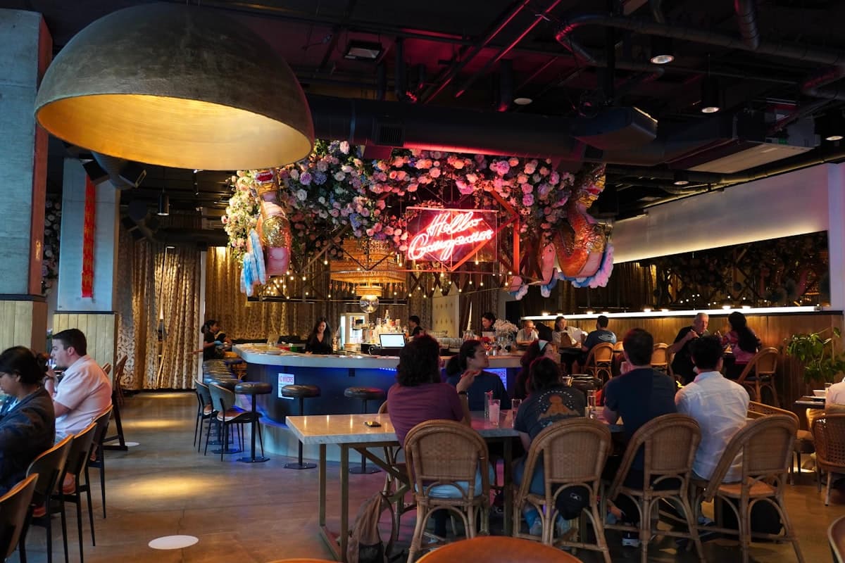Warm restaurant dining room filled with guests, drinks, and summer dinner energy