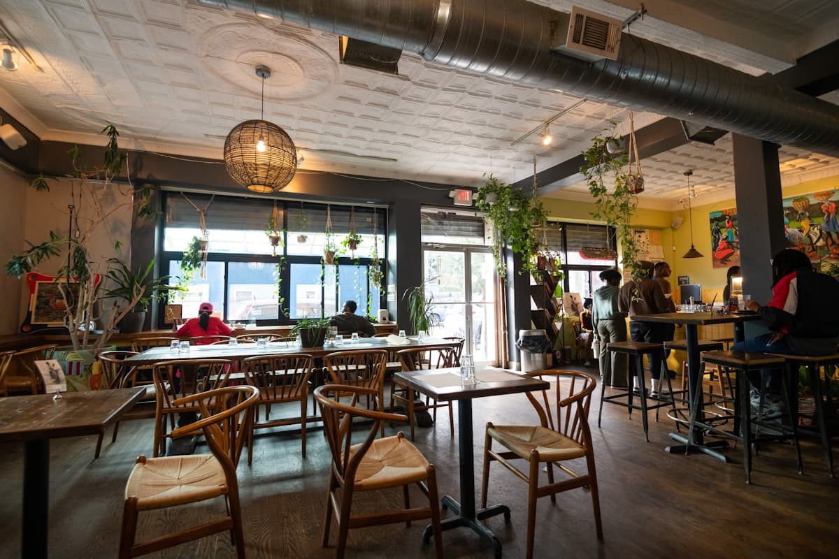 Stylish restaurant dining room with warm wood, intimate lighting, and lively cocktail-bar atmosphere