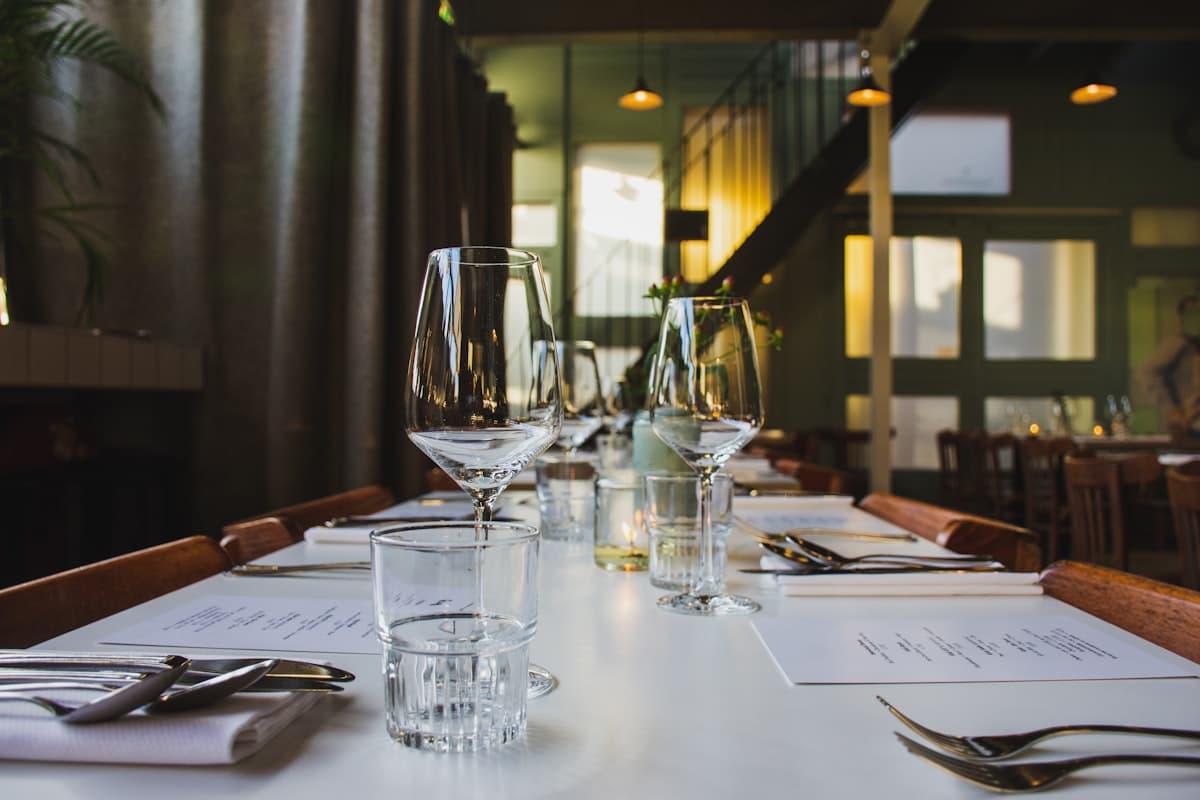A candlelit restaurant table with wine glasses set for a stylish dinner